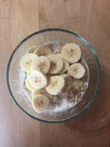 sliced bananas on top of oatmeal with almond milk and maple syrup