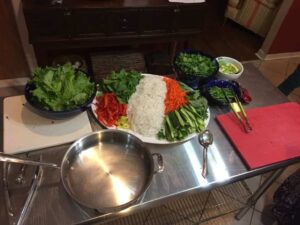 veggies and rice noodles on a plate next to tofu and a pan