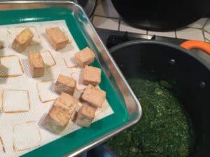 tofu heading into pan of vegan paneer
