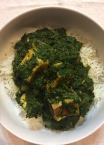 vegan saag paneer in bowl of rice close up