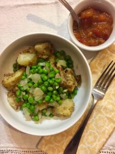 indian spiced potatoes with peas and onions close up