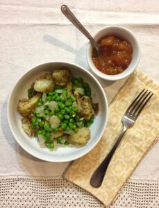 potatoes in bowl with mango chutney next to it.