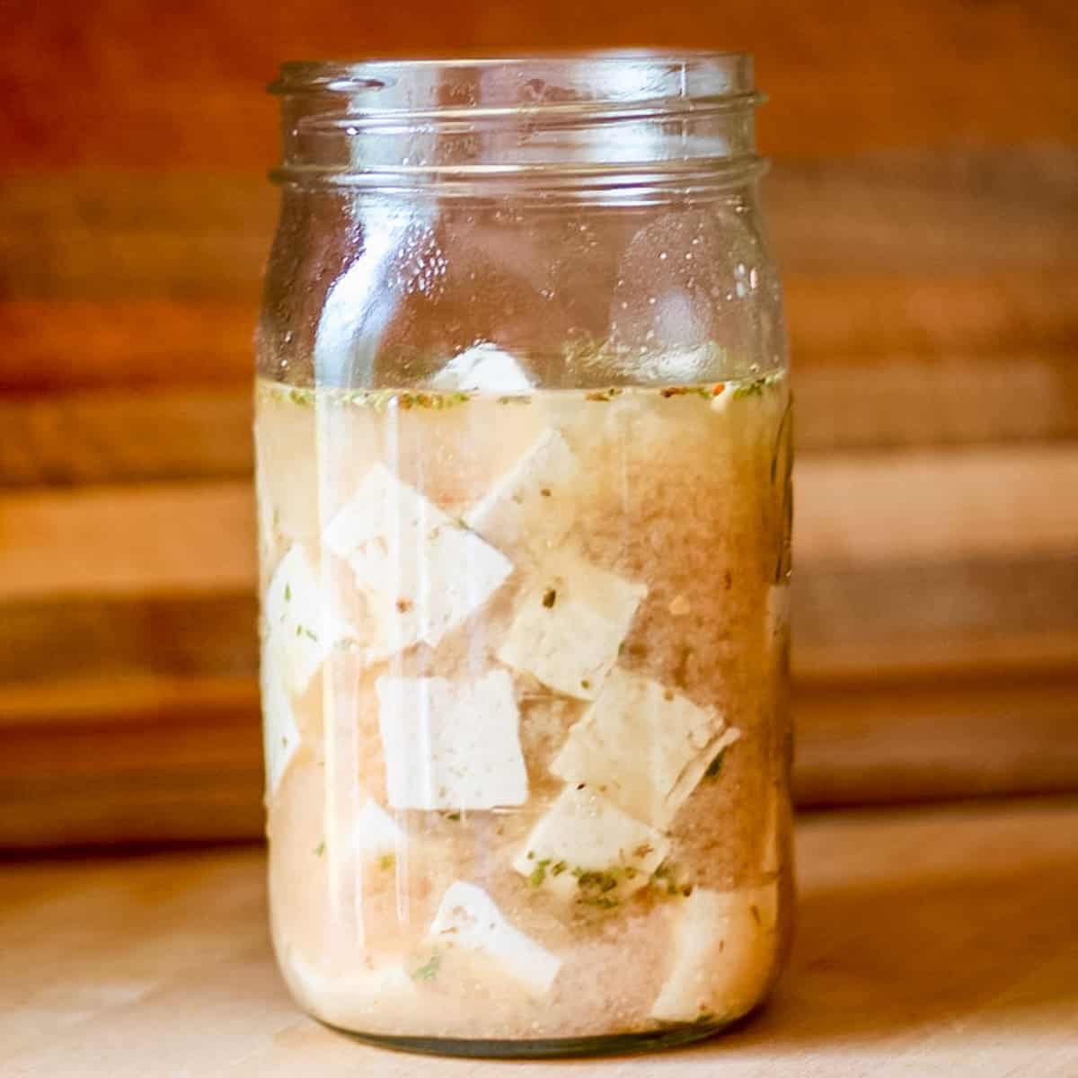 cubes of tofu feta in a glass jar