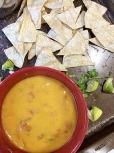 tortilla chips next to a bowl of queso