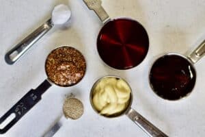 red wine vinegar, dijon mustard, whole grain mustard, maple syrup, salt and pepper in measuring cups