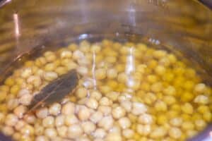 cooked chickpeas with bay leaf floating inside Instant Pot