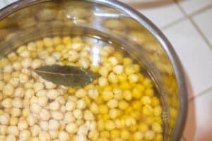 cooked chickpeas with bay leaf floating inside Instant Pot