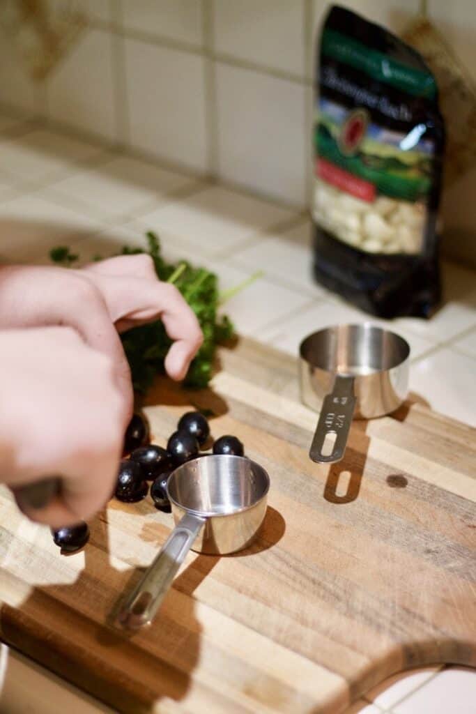 slicing black olives on a cutting board