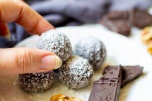 grabbing a chocolate coconut date ball