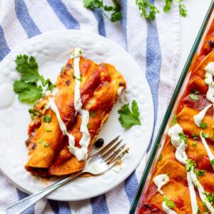 two enchiladas on white plate with fork