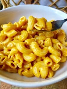 fork with macaroni and cheese in a bowl