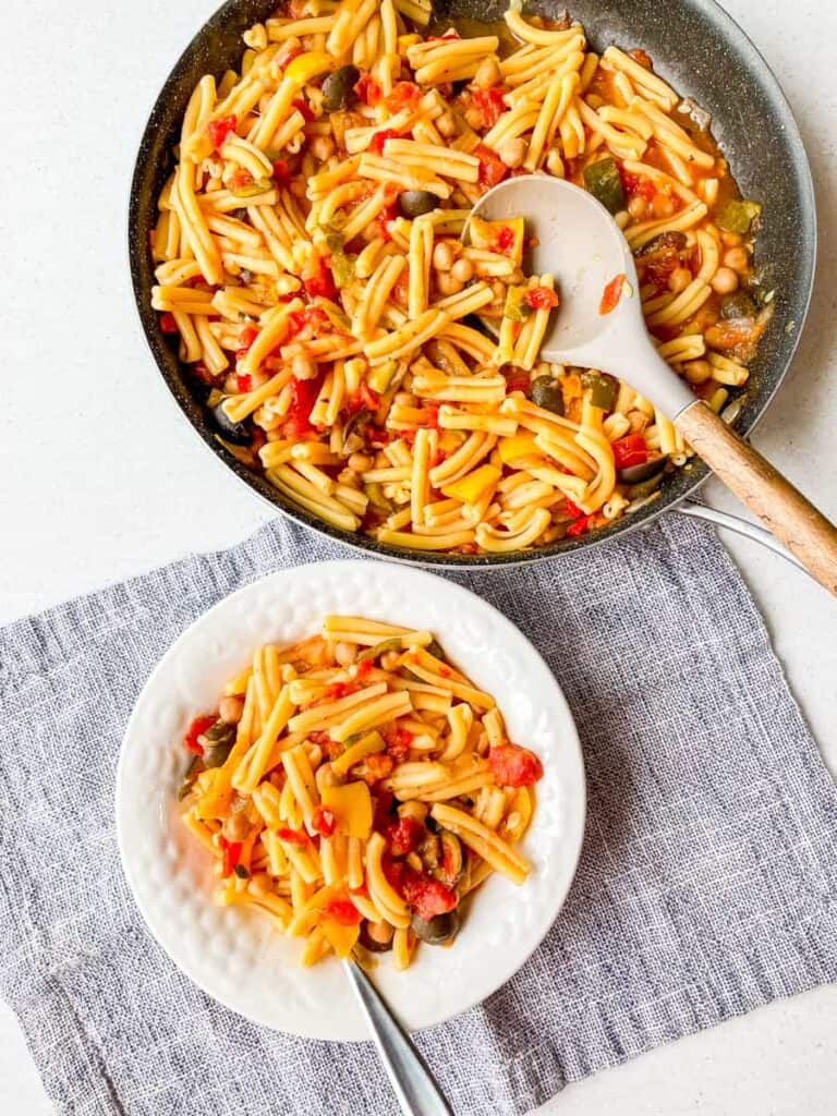 pan and bowl of mediterranean pasta with vegetables