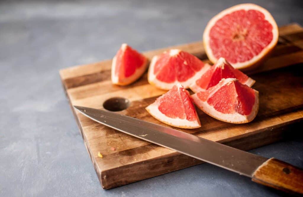cut pink grapefruit on cutting board