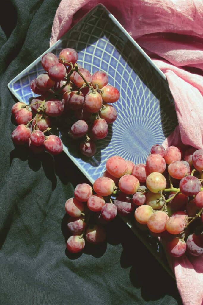 light pink purle grapes on blue platter