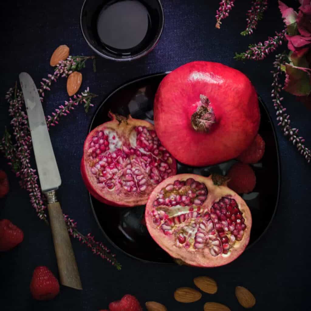 sliced pink pomegranate on black plate