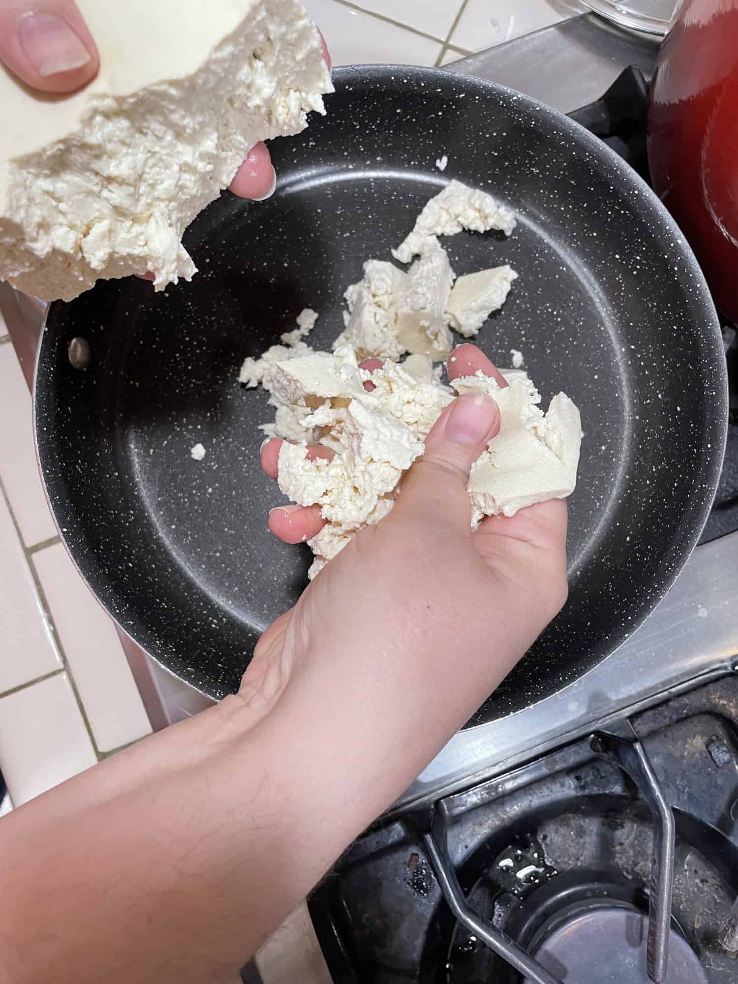 crumbling tofu into pan