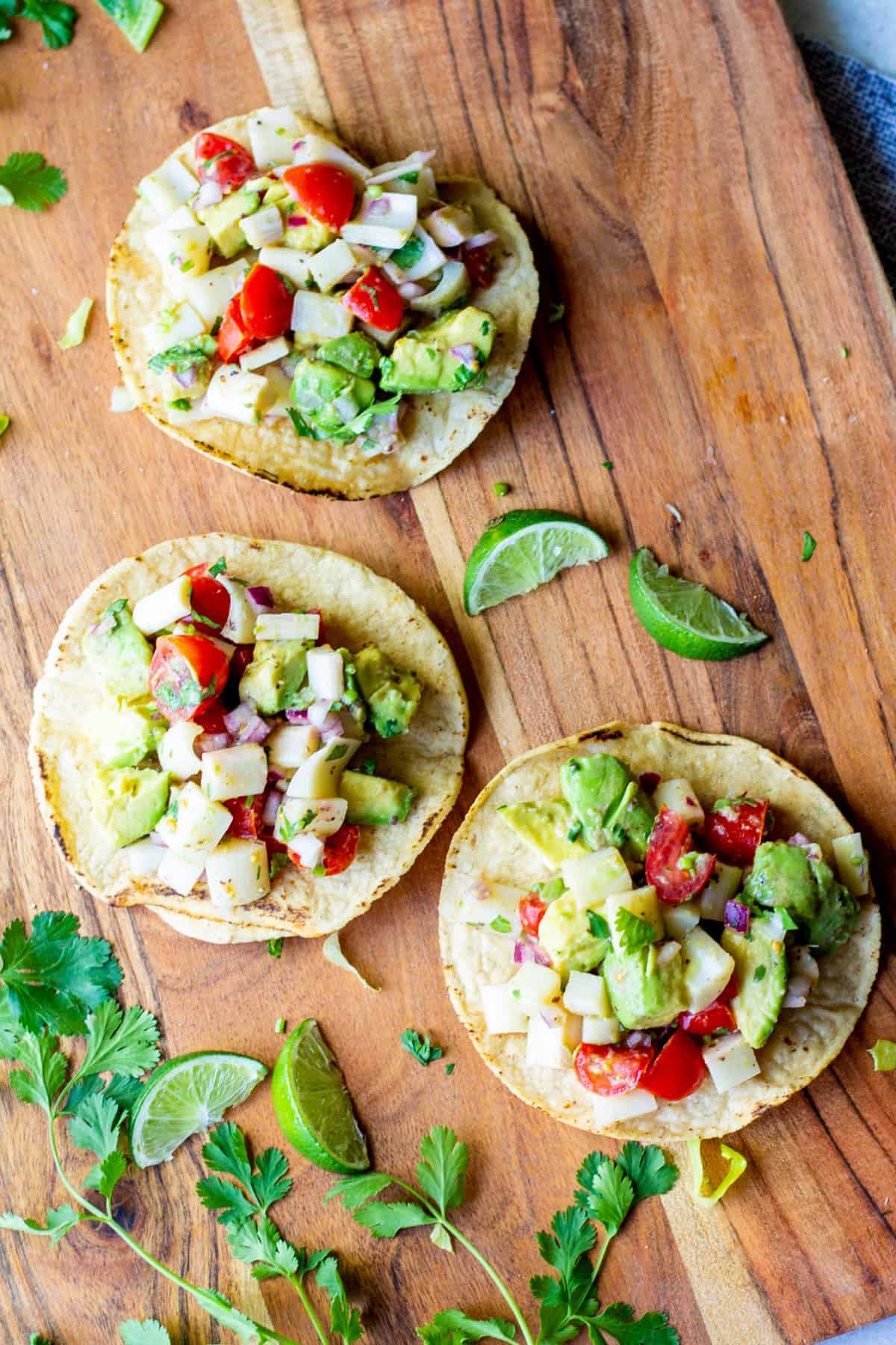 three tostadas with ceviche on wooden board