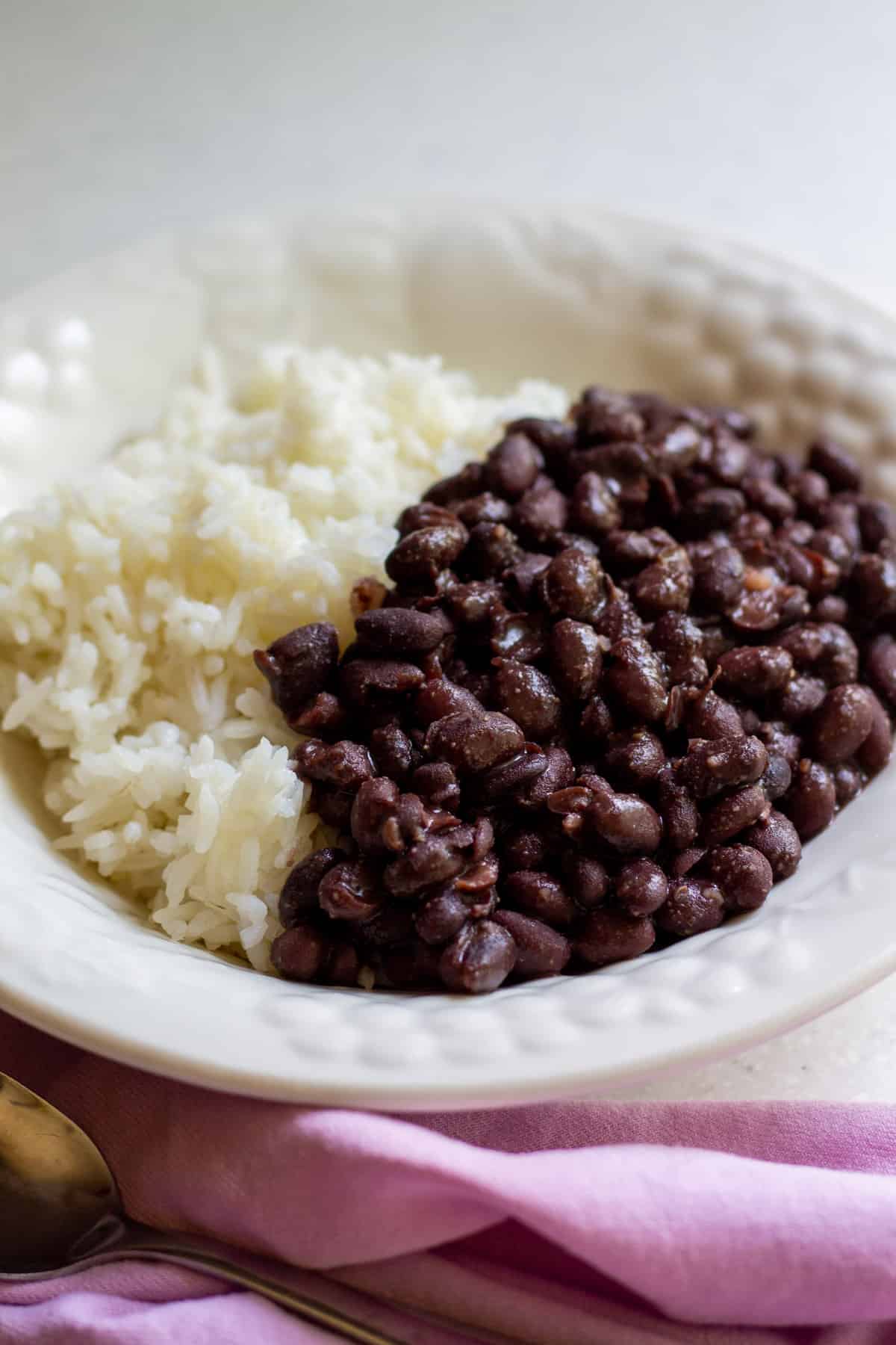 cooked black beans with cooked white rice in a white bowl