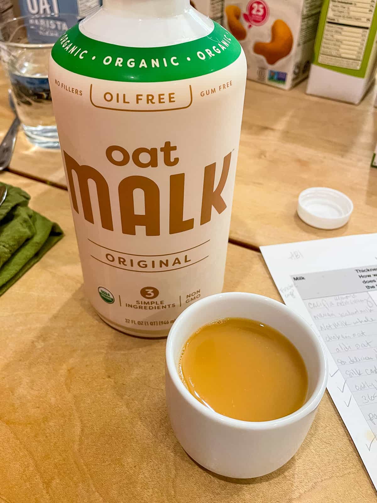 carton of oat Malk oil free with cup of tea in front