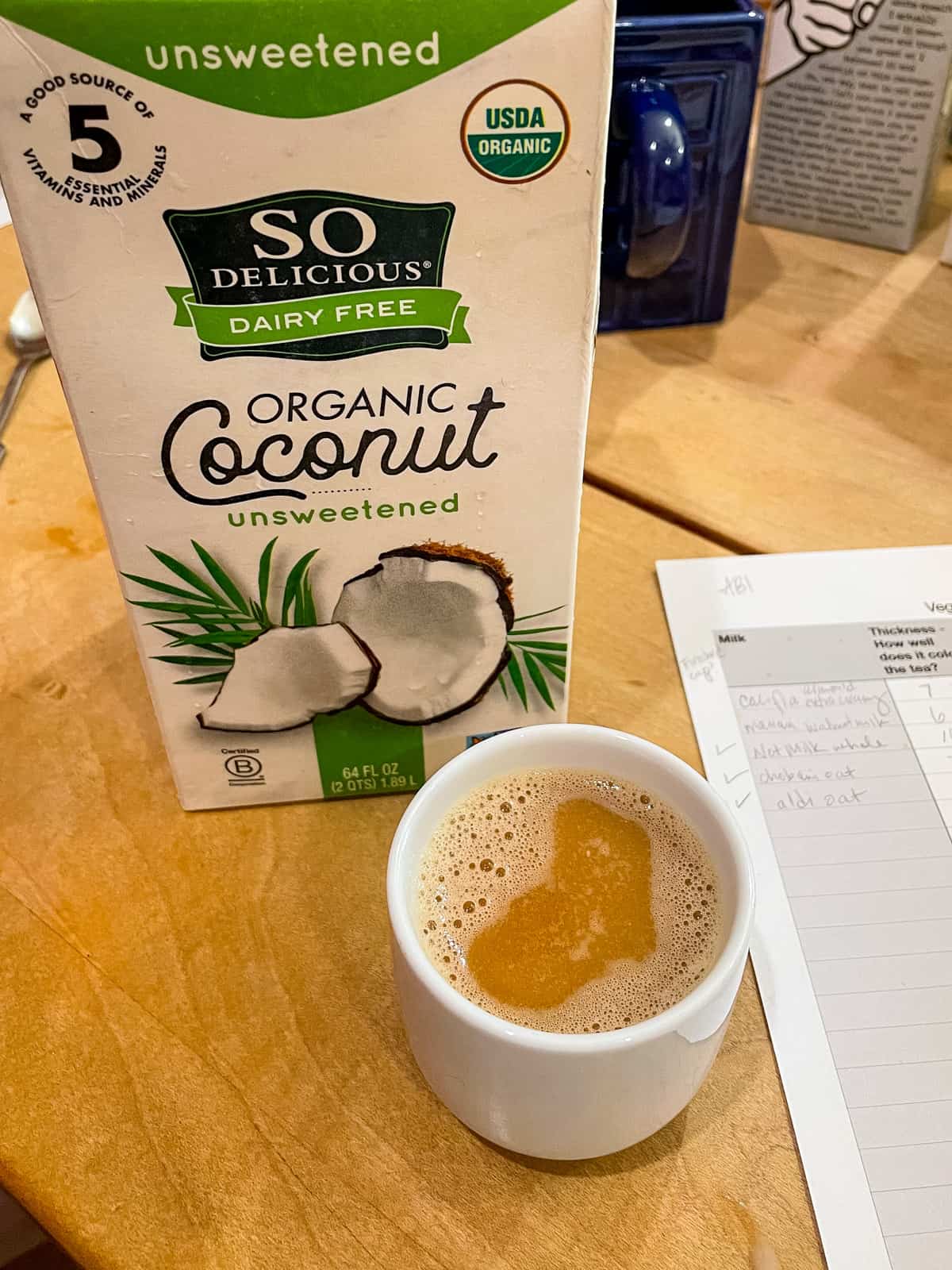 carton of so delicious organic coconutmilk unsweetened with cup of tea in front