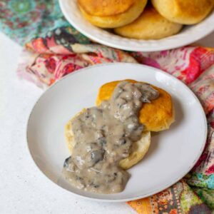 biscuit with vegan creamy mushroom gravy on top with biscuits in background