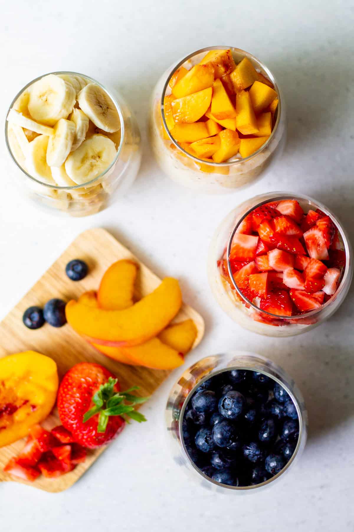 four glasses with fruit and oats