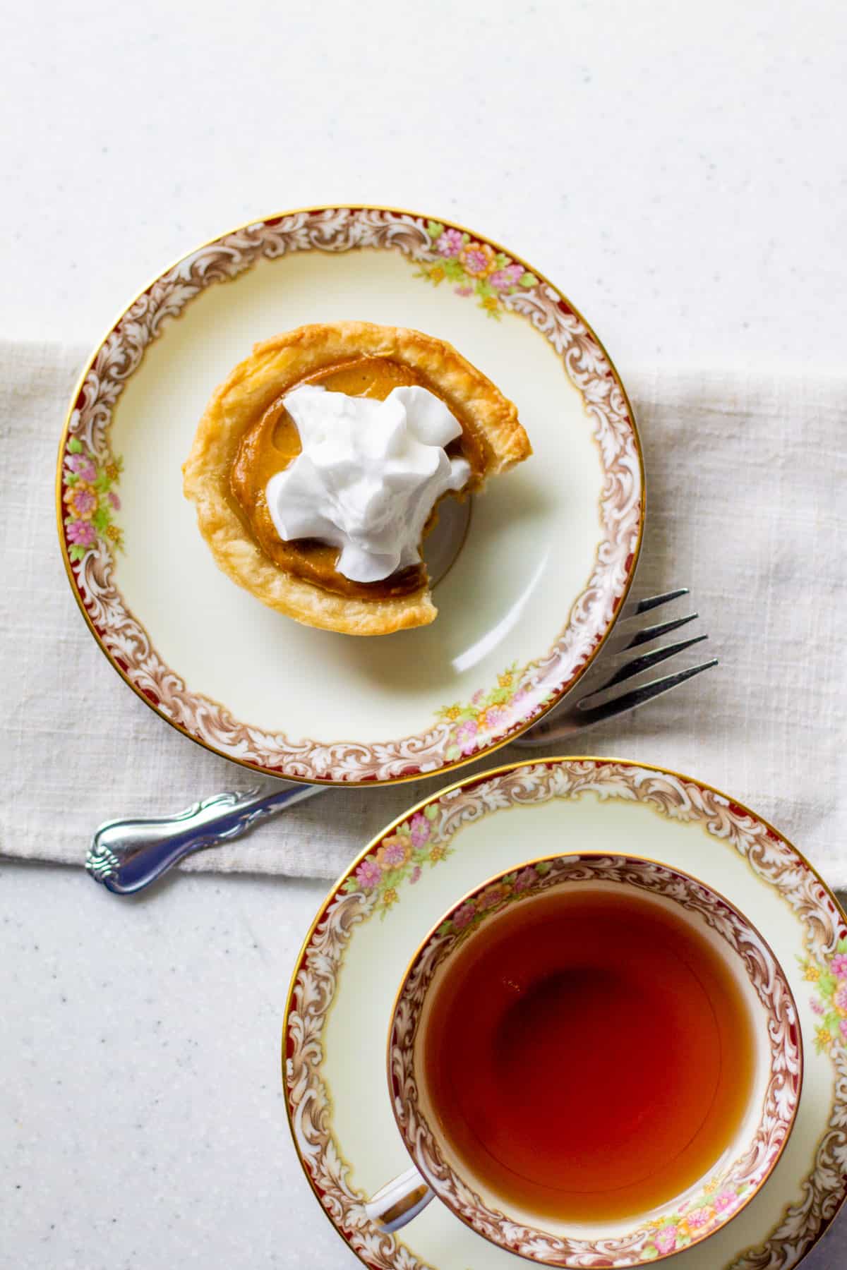 mini pumpkin pie on plate with darjeeling tea in cup