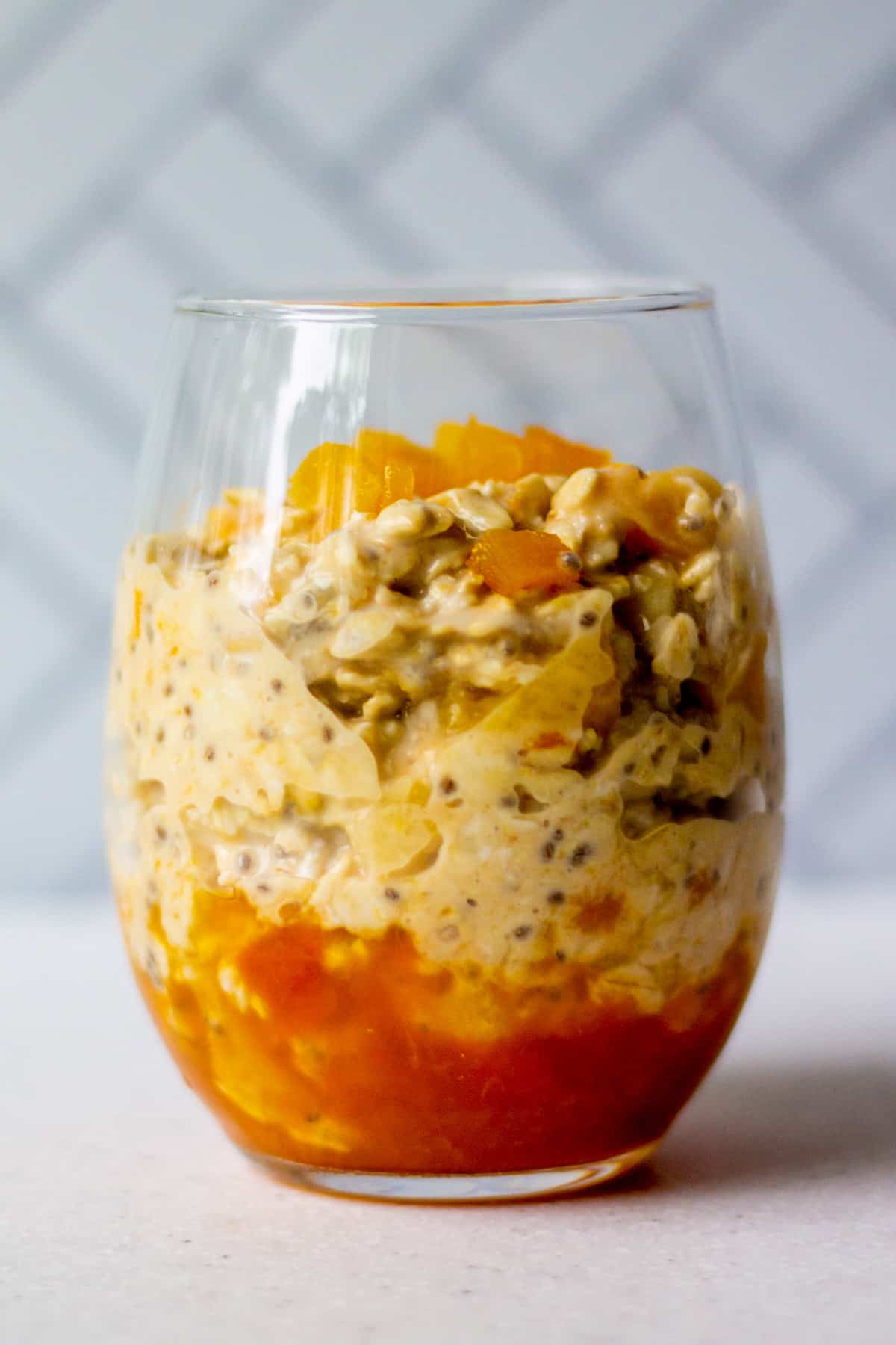 glass cup with apricot preserves, overnight oats and dried apricots