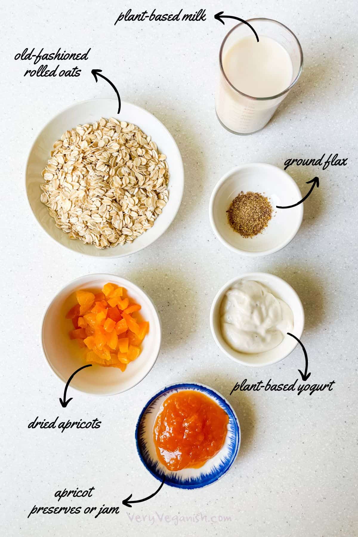 ingredients for apricot overnight oats: old-fashioned rolled oats, plant-based milk, ground flax, plant-based yogurt, dried apricots and apricot preserves or jam