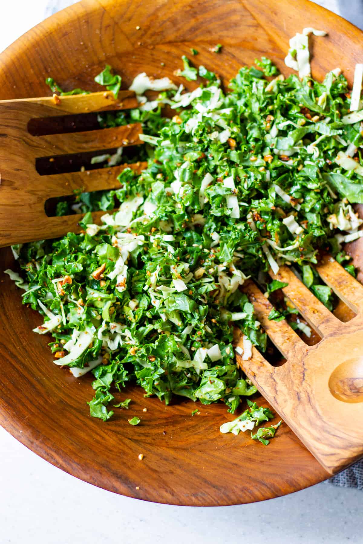 tossing salad in wooden bowl