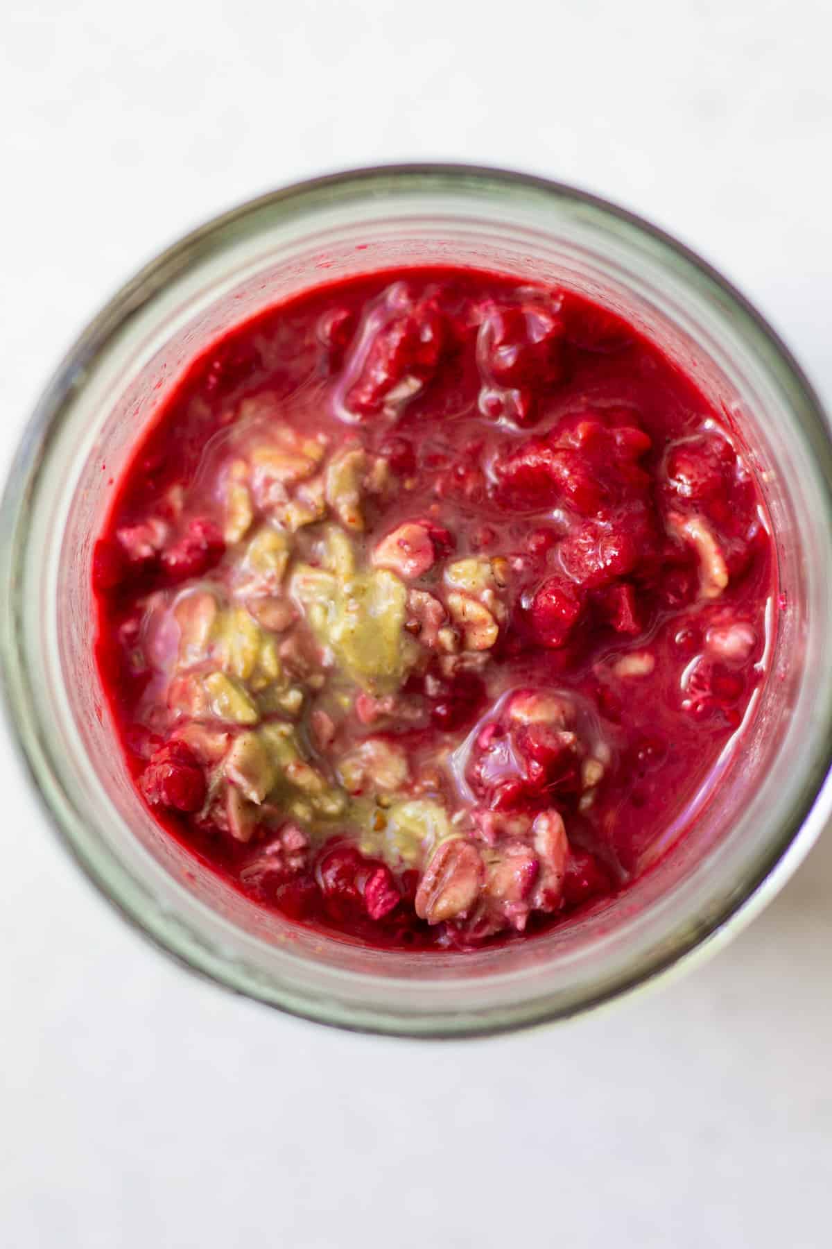 matcha raspberry overnight oats mixed up in jar