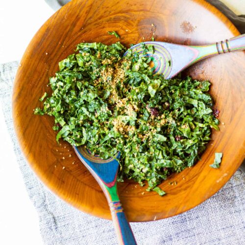 salad bowl of kale salad with spoons for tossing