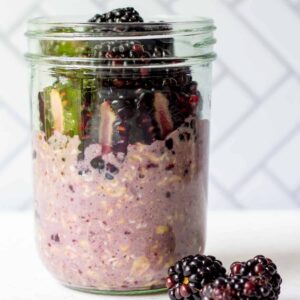 blackberry jam overnight oats with fresh blackberries on top in a mason jar