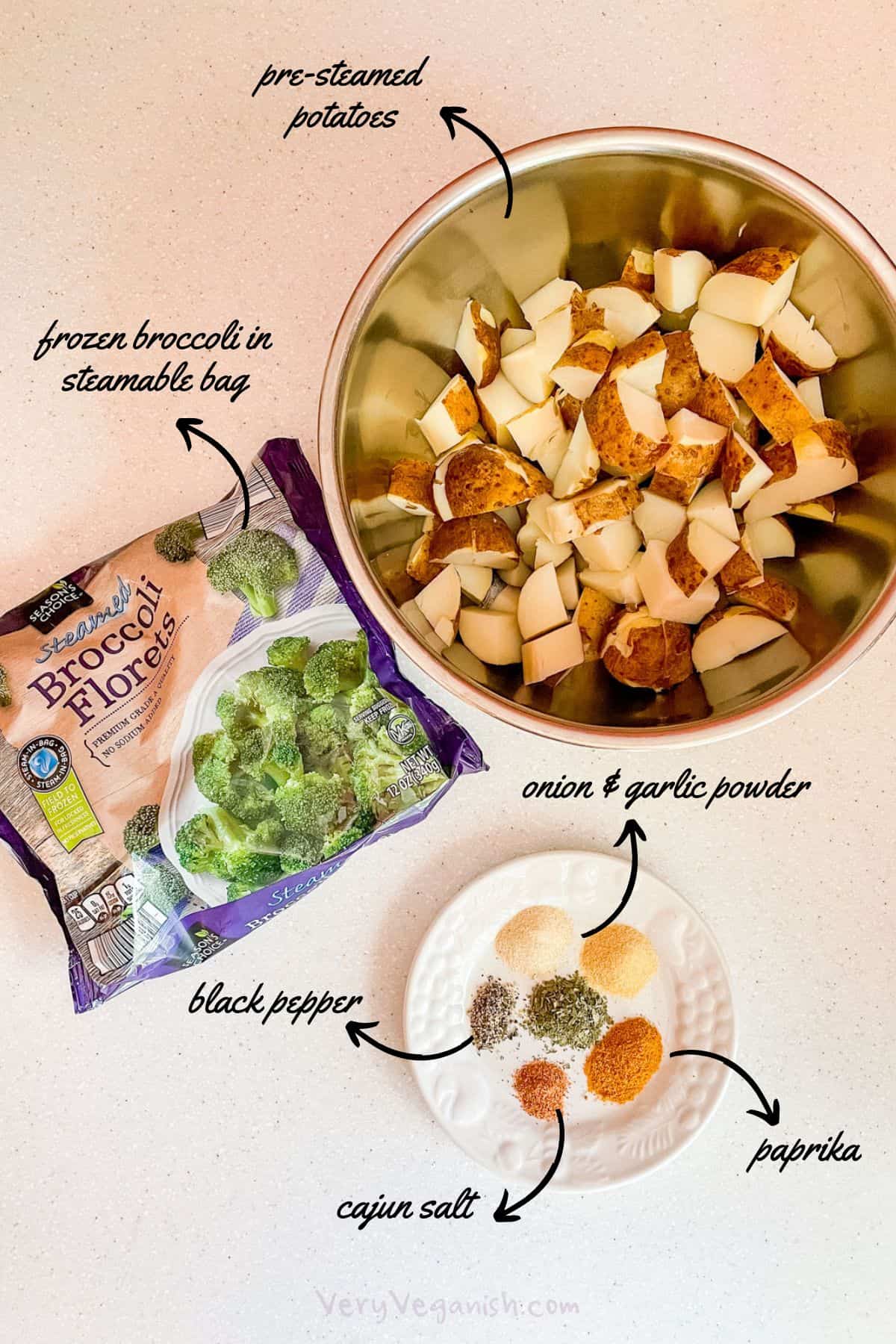 Ingredients for oil-free roasted potatoes and broccoli: frozen broccoli in steamable bag, cut pre-steamed russet potatoes, onion powder, garlic powder, paprika, cajun salt, black pepper
