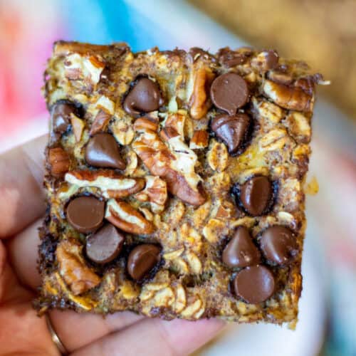closeup of a square cut banana oat bar with chocolate chips and chopped pecans