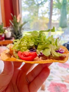 holding the tostada underneath like a tray