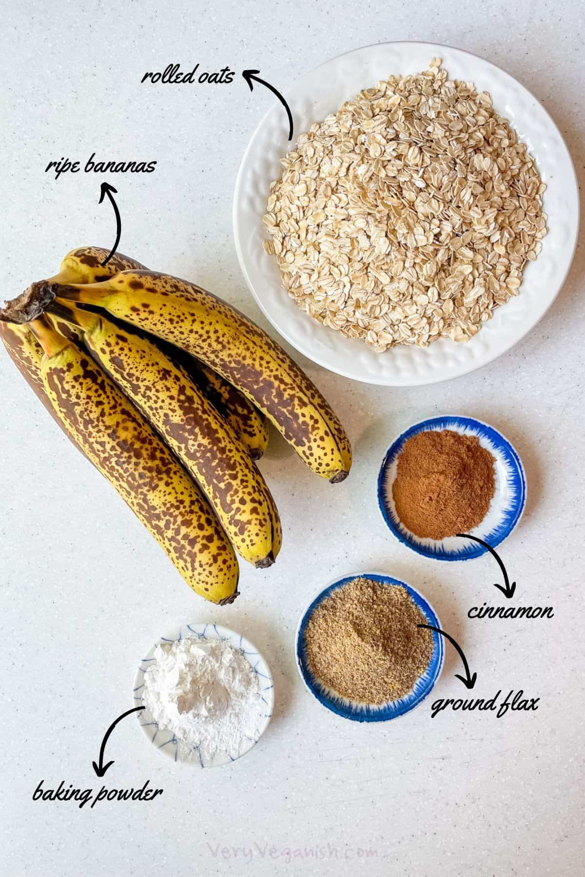 Ingredients for vegan banana oat bars: rolled oats, a whole bunch of ripe bananas, cinnamon, ground flax and baking powder