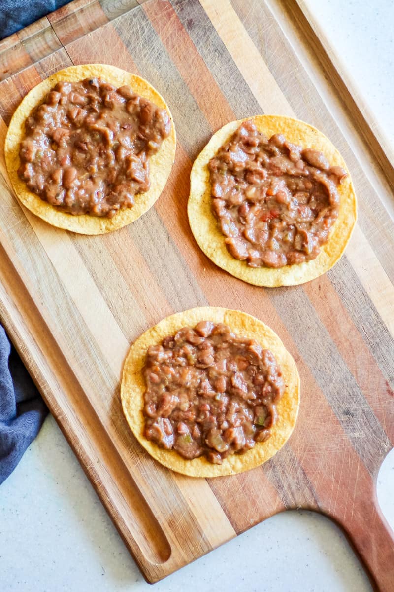 tostadas with beans on a wooden board