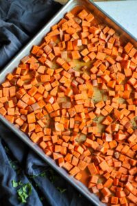 before baking Spicy Roasted Chili Sweet Potatoes on lined tray