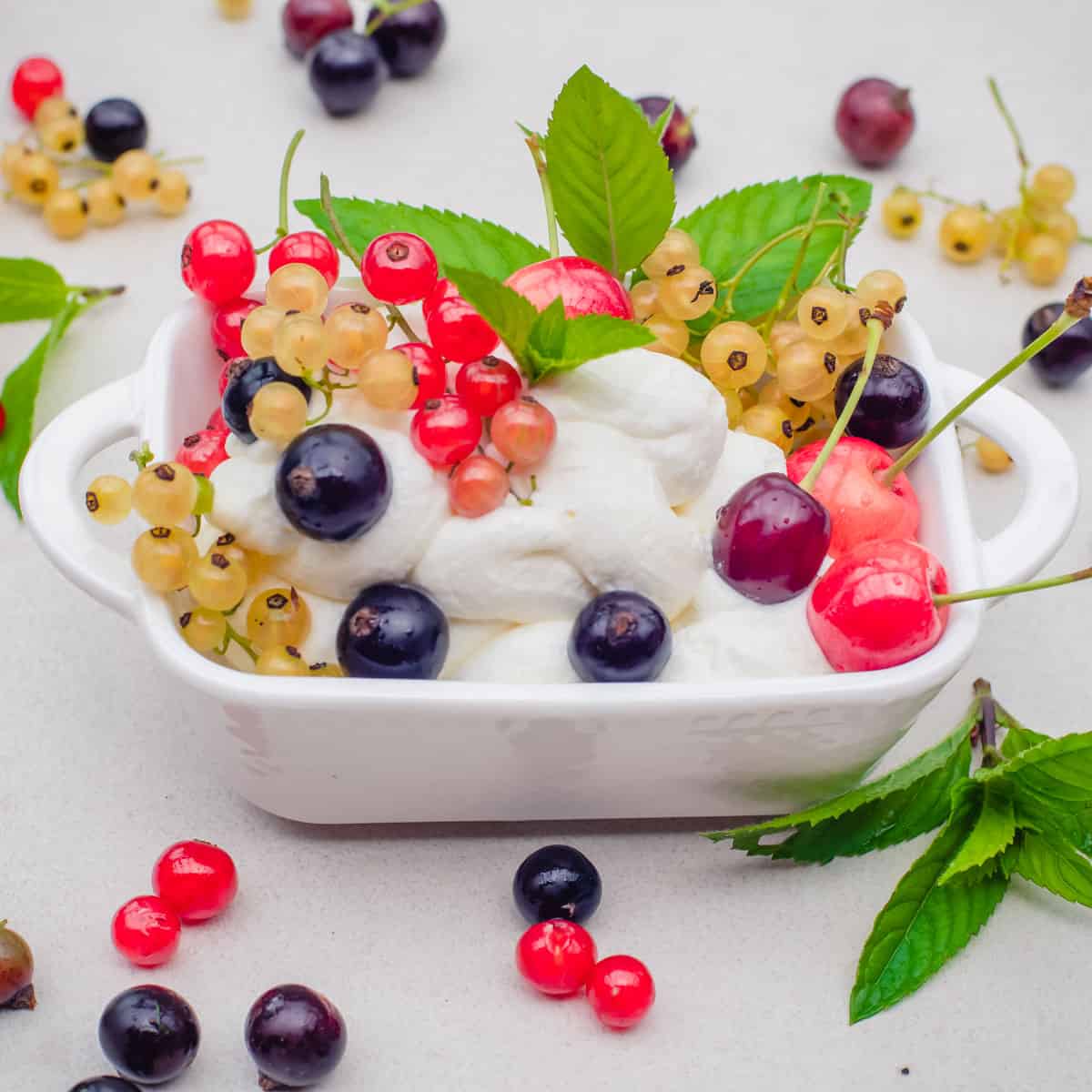 pink currants, black and white currants over yogurt