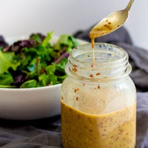 simple honey mustard oil-free dressing in jar with bowl in background