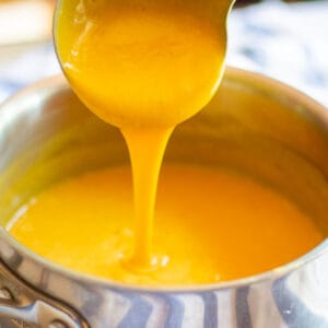 pouring vegan cheese sauce from ladle into saucepan