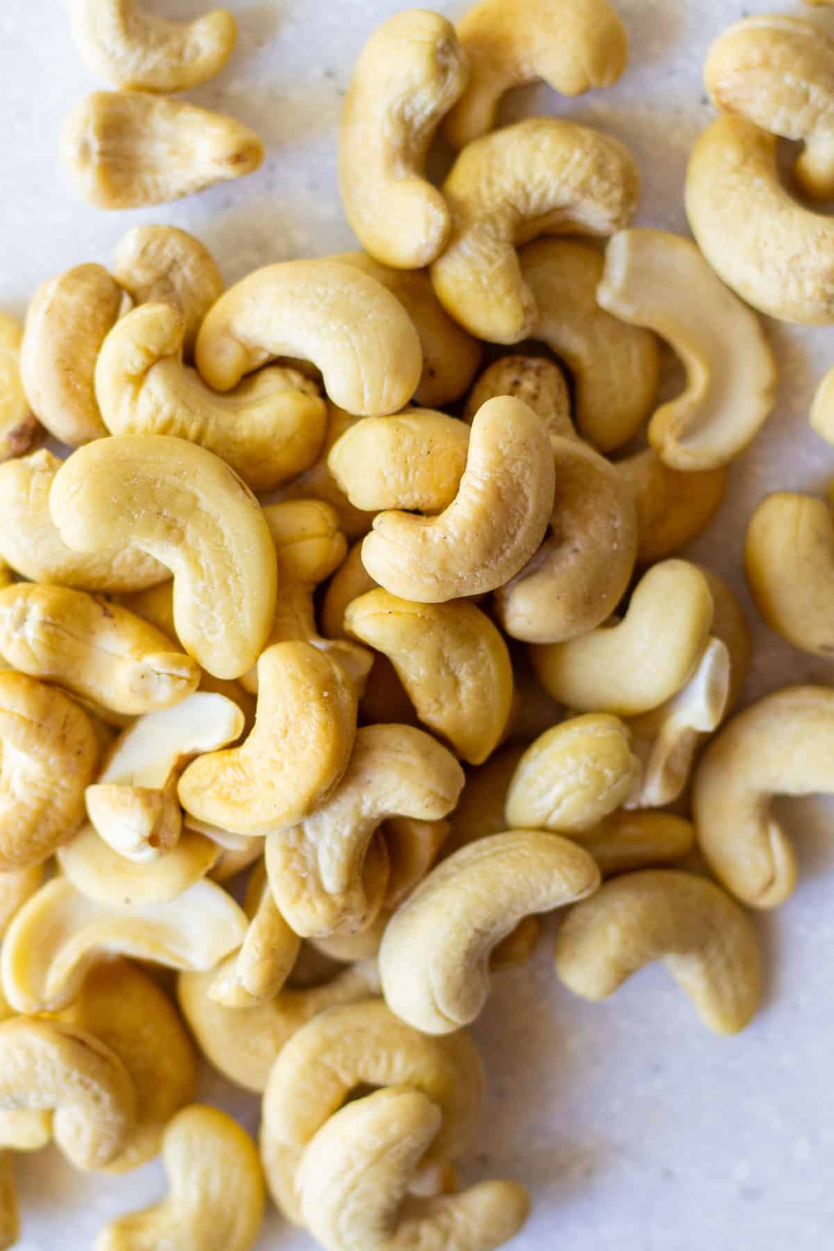 raw cashews scattered on white counter
