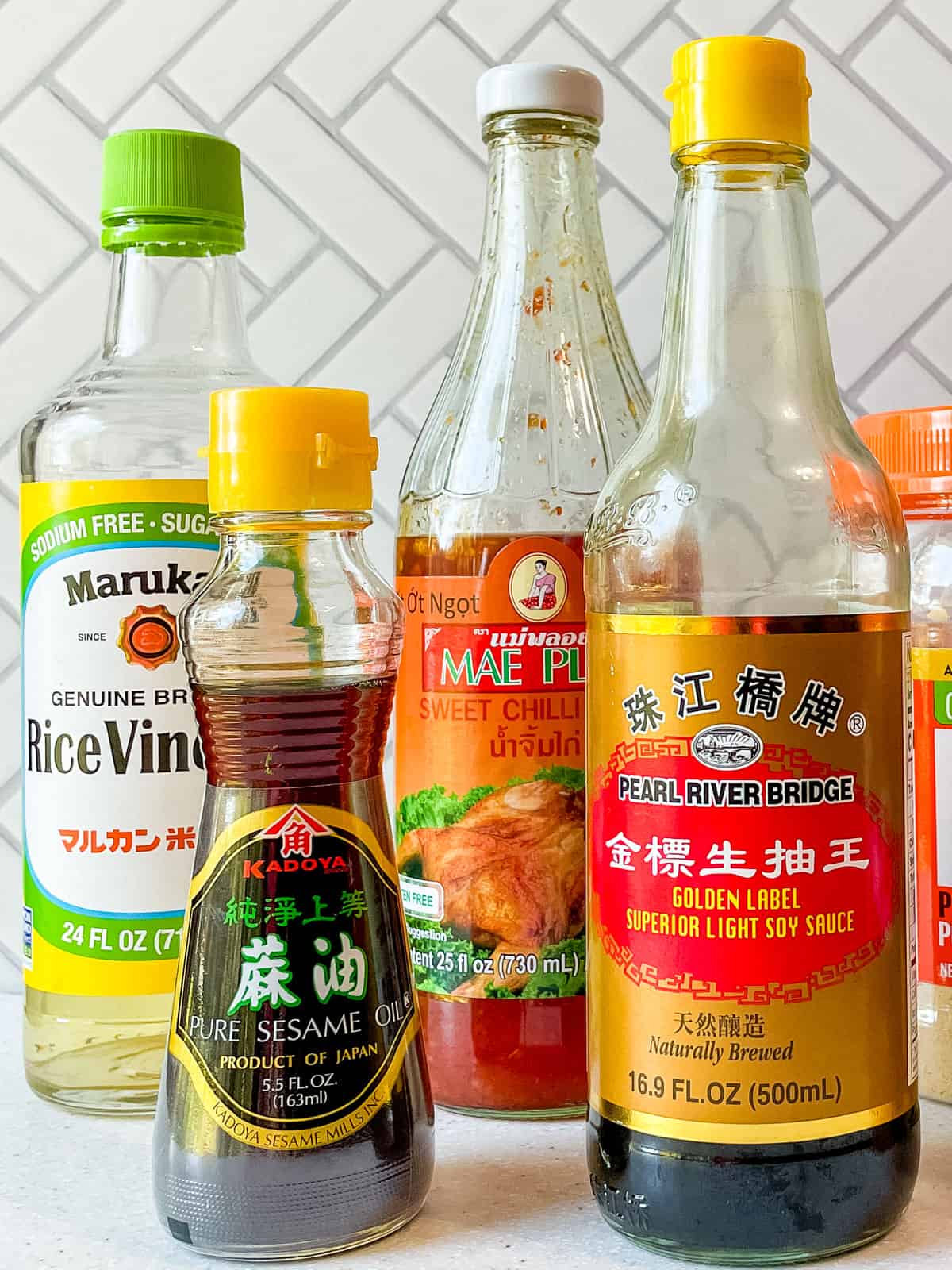 bottles of rice vinegar, toasted sesame oil, sweet chilli sauce and soy sauce on counter