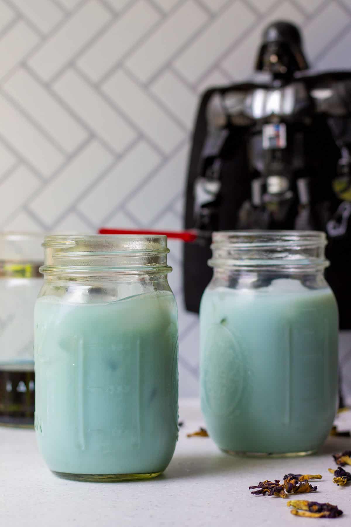 two glasses of blue milk with darth vader figure standing in the background
