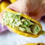 holding an arepa with vegan chicken jackfruit salad filling