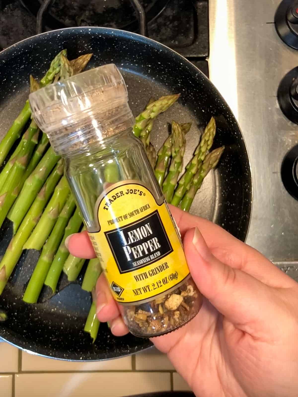 Step 3 seasoning asparagus in pan with salt and lemon pepper