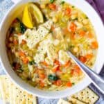 white bowl full of soup with saltine crackers on top