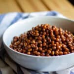 white bowl full of cooked pigeon peas with a white and blue striped towel