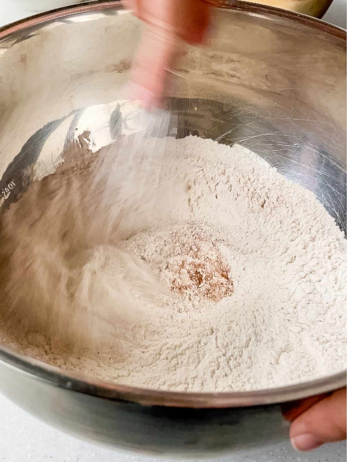 in a metal bowl, whisking dry ingredients